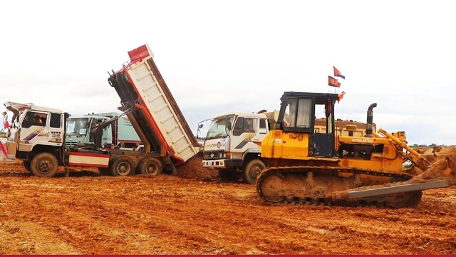 工地热闹场景,双桥车卸载土,推土机帮忙推平