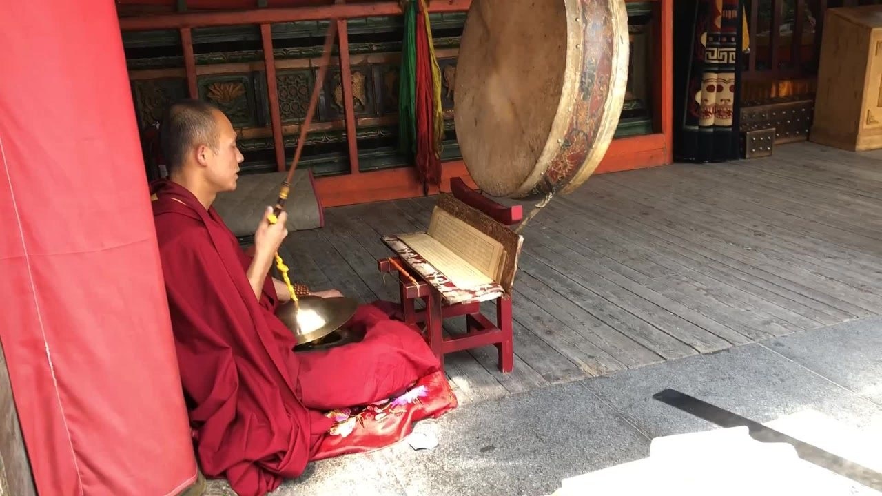 青海西宁塔尔寺l喇嘛在寺院边敲鼓边诵经