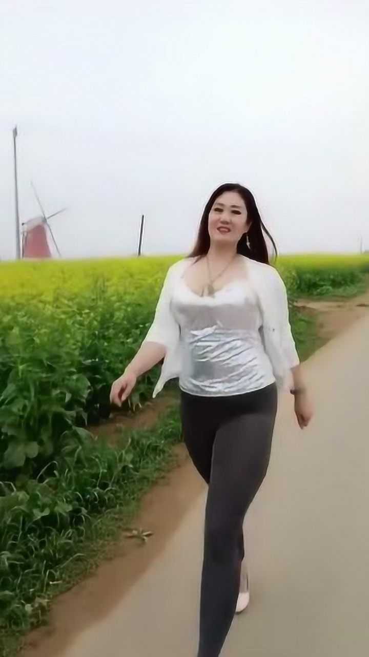 肥硕丰满的东北大姐,在油菜地里走秀,韵味十足!