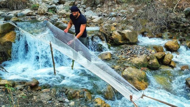 牛人用在河流中搭建三米“悬空”长网,鱼哗啦啦的从网中滚下来