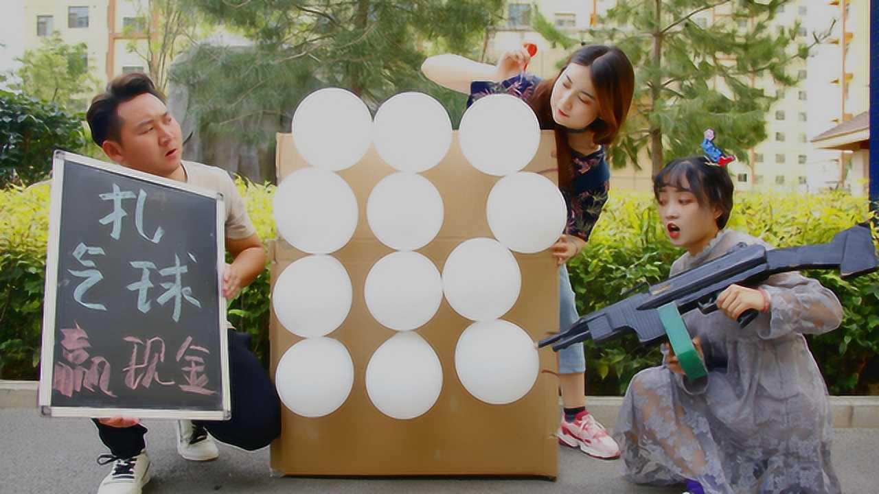 姐妹俩玩飞镖扎气球,一个在前面打一个在后面扎,真有趣