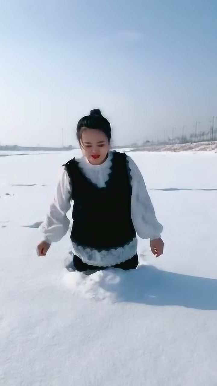 美女在雪地里走由于大雪太深了把腿都给埋没了