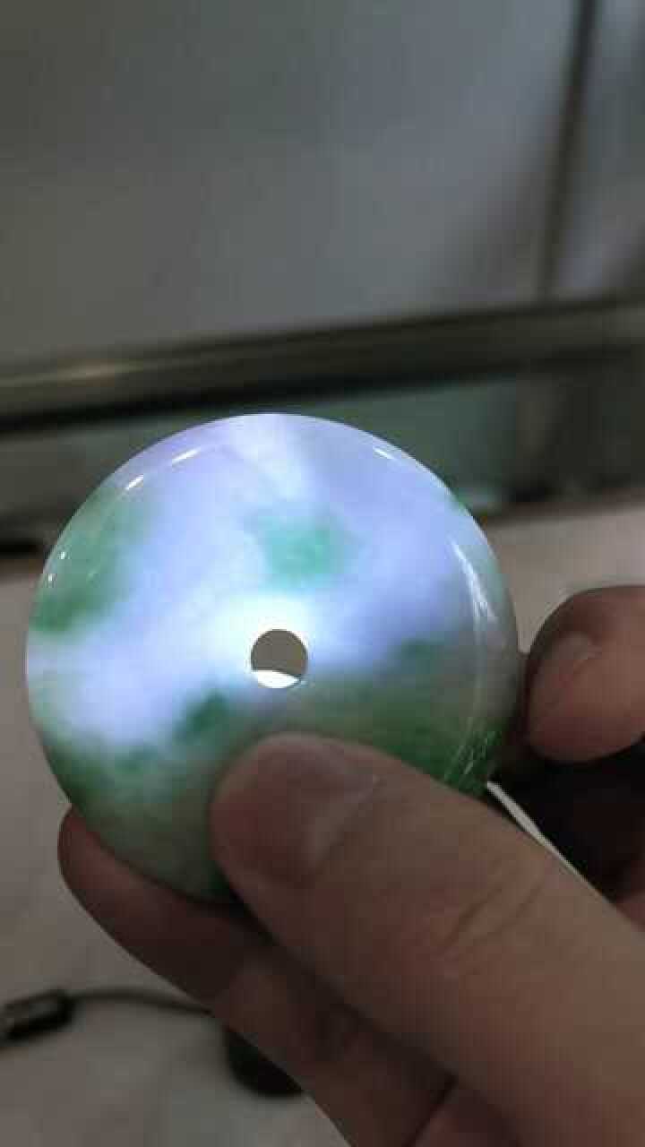 灯光下的翡翠平安扣清晰可见的玉石纹理