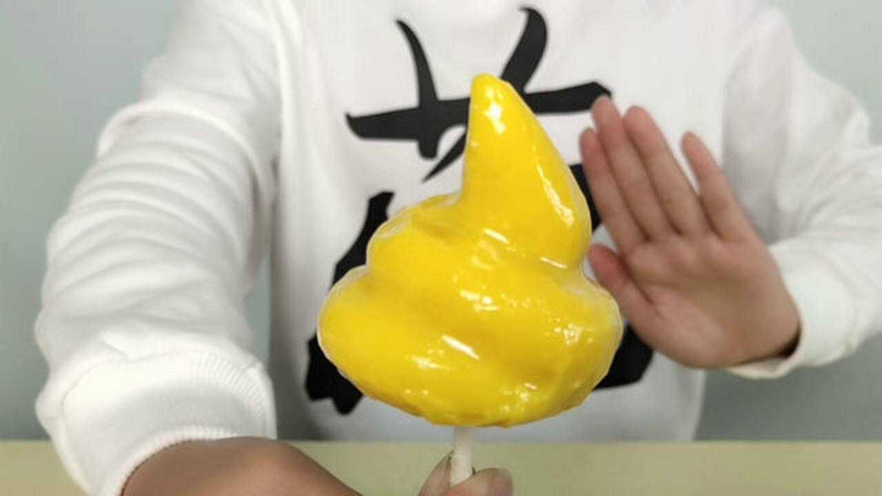 小姐姐吃趣味零食"屎状棒棒糖",金黄闪亮,闭上眼睛尝甜蜜