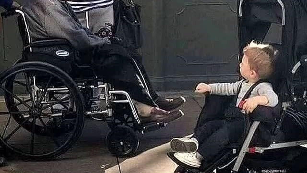 轮椅中年迈的老人和婴儿车里天真儿童世界对视