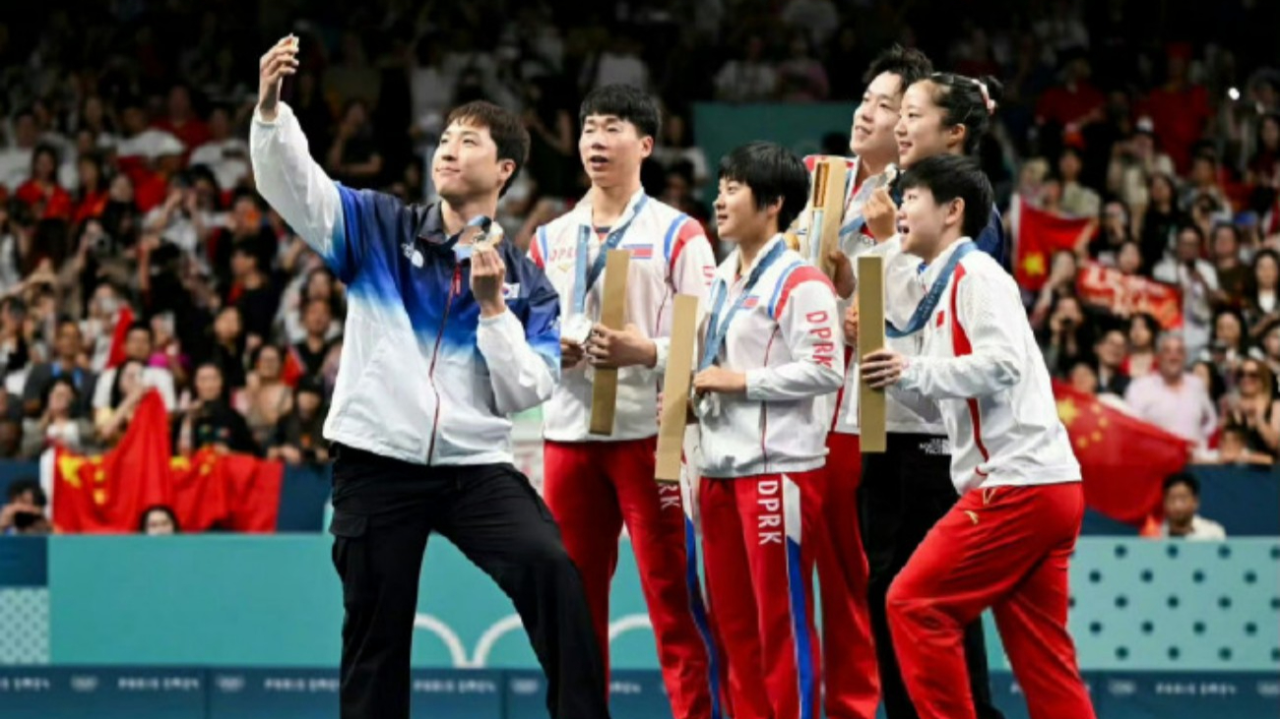 本届奥运会值得纪念一幕:朝鲜与韩国选手互动后合影