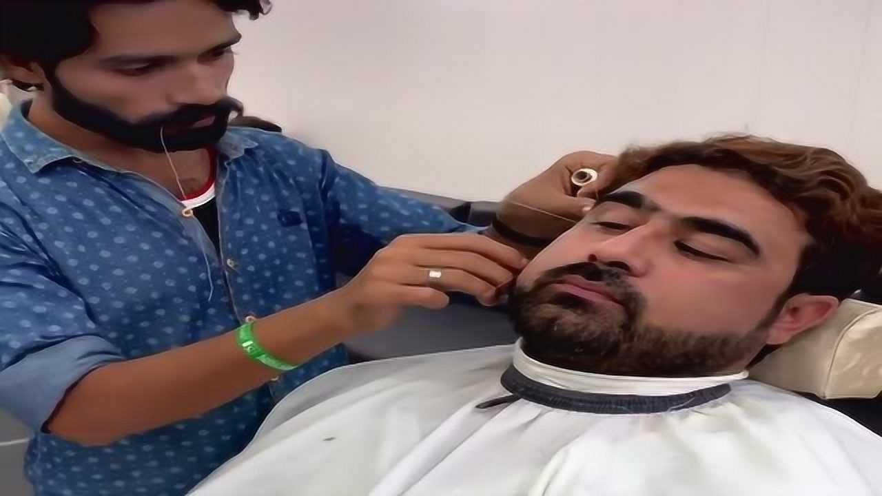 外国小伙绞脸,理发师用一根线当剪刀,小伙露出害怕的眼神