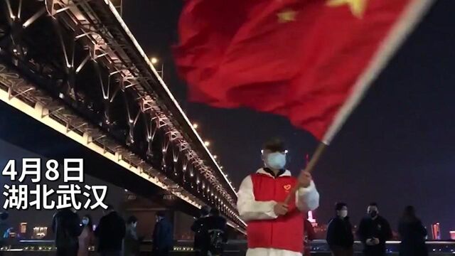 30秒丨灯光下,志愿者挥舞国旗为武汉加油