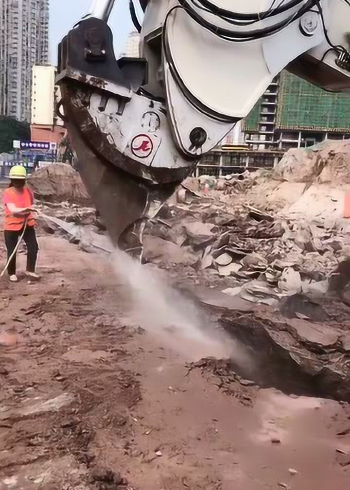 挖掘机凿地面,用水冲刷一遍才容易凿开,地质太硬了