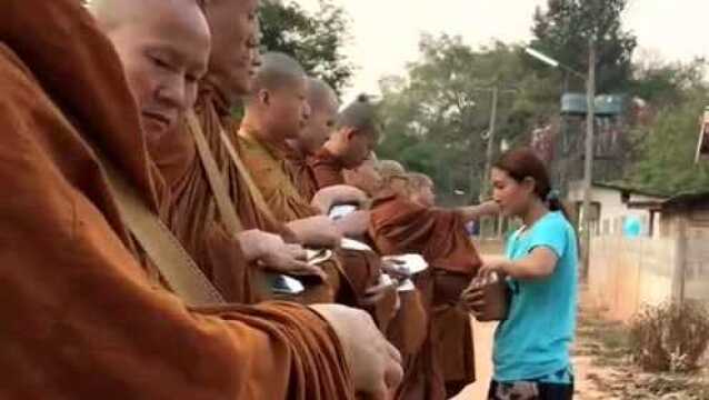 泰国街头的佛教信徒,女施主施舍干粮,简单的仪式即将完成!