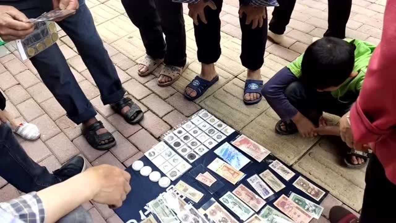 路边一摆摊在收老钱币年代越久越值钱这种币看着能换不少钱