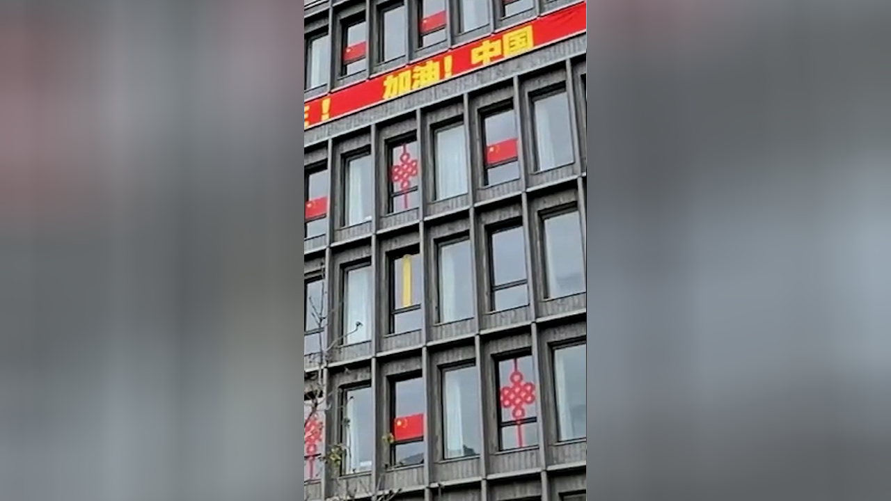 五星红旗高高挂在巴黎奥运村 现场拉起"加油中国"横幅