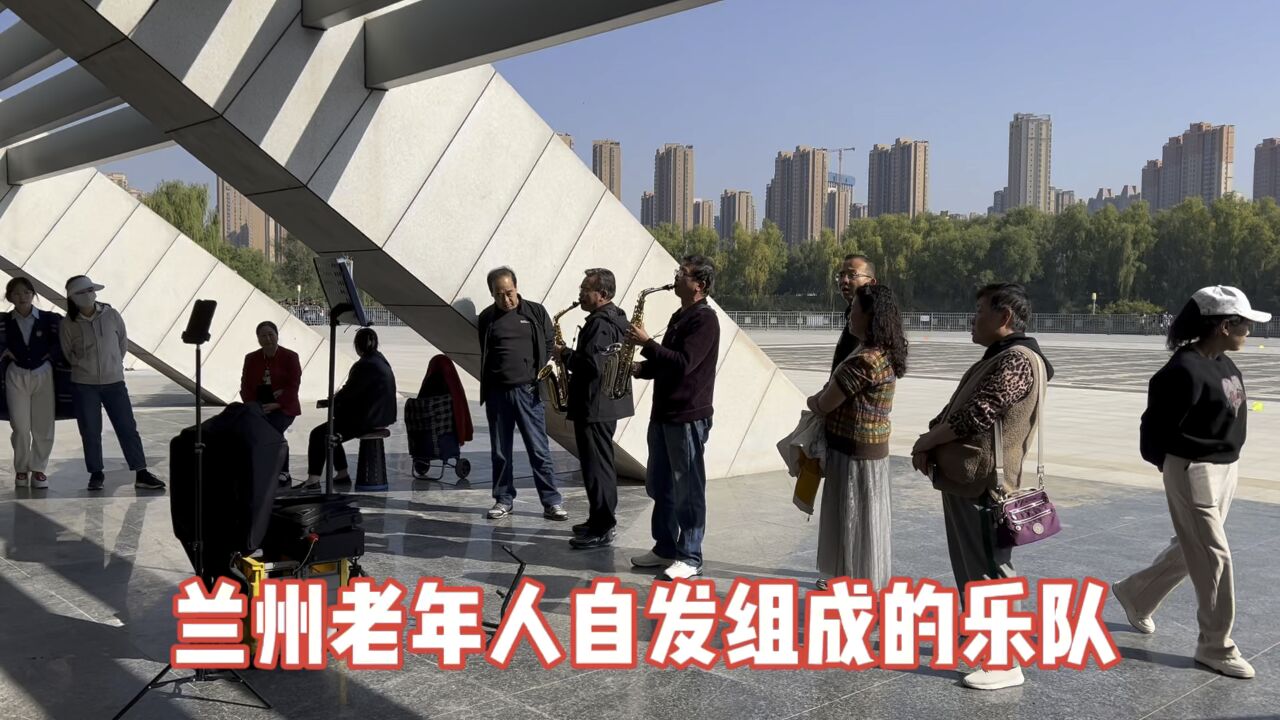 兰州老年人自发组成的萨克斯乐队在湿地公园演奏《北国之春》围观的人