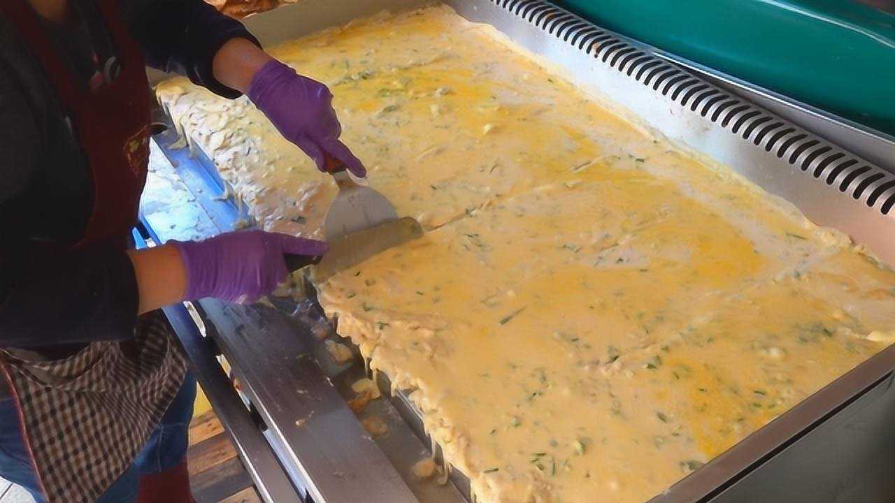 大妈街头摆摊卖鸡蛋饼,巨大的铁板倒上鸡蛋液,翻面的一刻馋到了