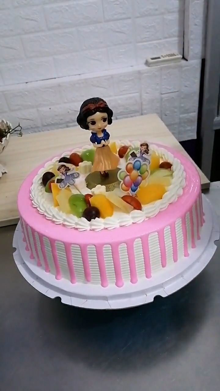 这是一个白雪公主的生日蛋糕粉色的奶油配上水果特别好吃