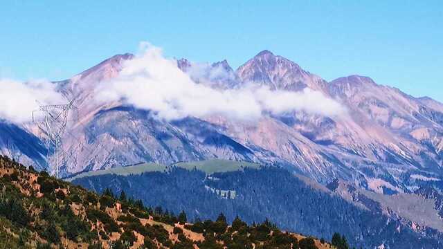 川藏线红土地拉乌山,远眺飘着云朵的觉巴山