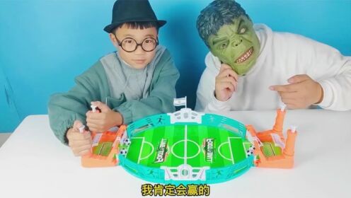 小泽和绿巨人玩桌面足球对战玩具，按动手柄控制足球发射，很好玩