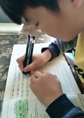 孩子太有才了,两支笔写字