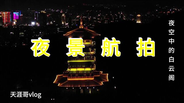 航拍夜空中的白云阁,金黄色的光芒映入眼帘,远处的城区星光璀璨