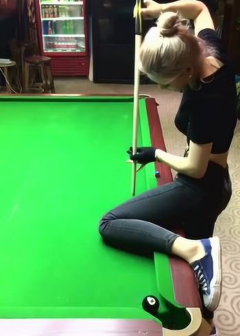 美女把腿抬到桌面上展示花式台球一杆进洞