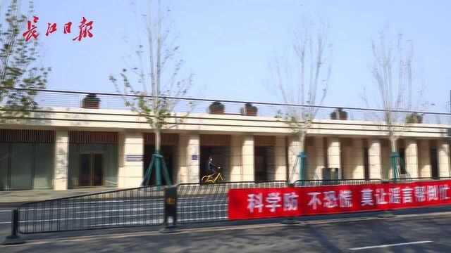 “众志成城 共渡难关”,城管在辖区交通护栏上悬挂宣传条幅