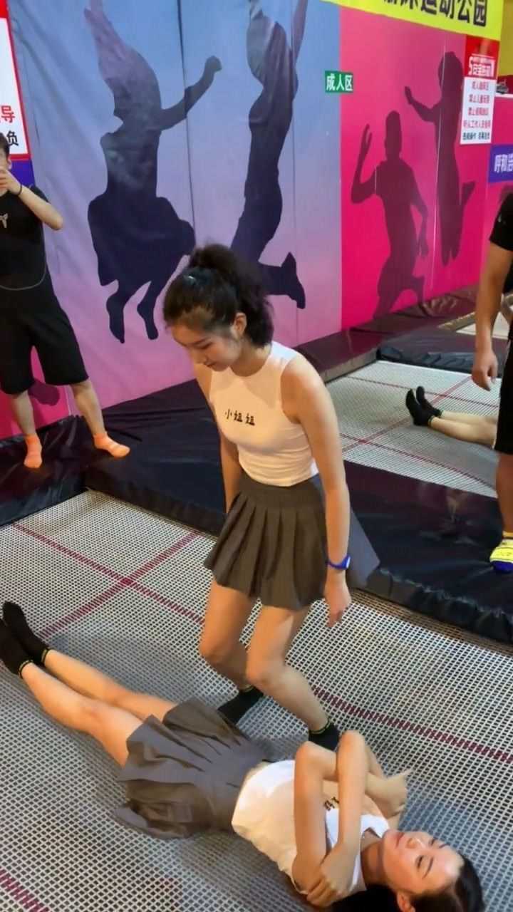 美女穿短裙玩蹦床一直用手捂着裙子生怕走光了啊