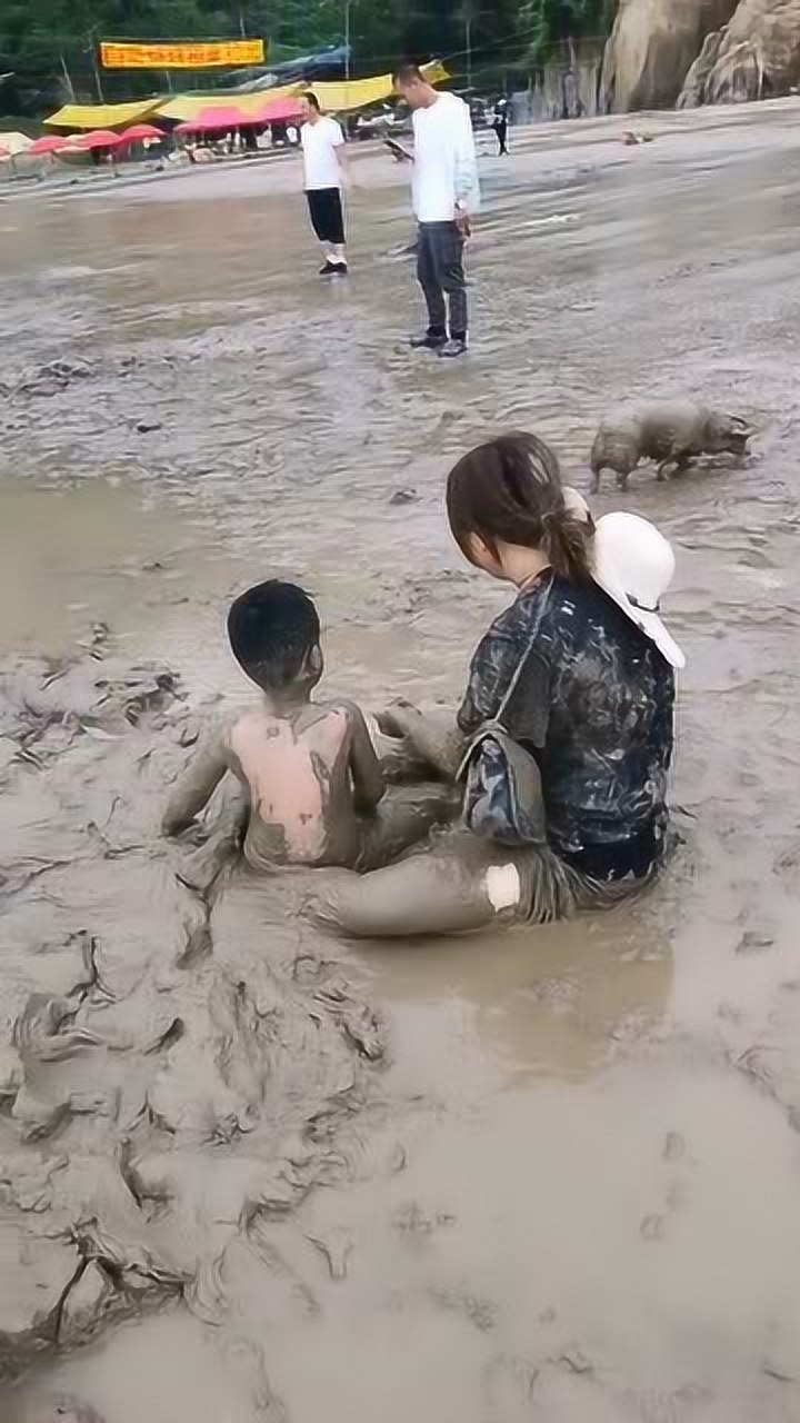 妈妈带着儿子在泥潭里打滚玩的真开心有其母必有其子