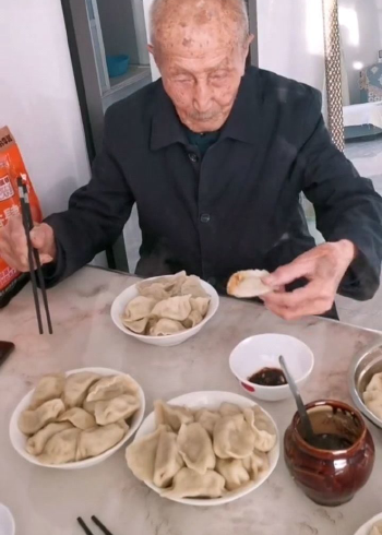 好可爱啊!爷爷吃饺子的时候,不停地往碗里夹饺子,深怕别人跟他抢似的!
