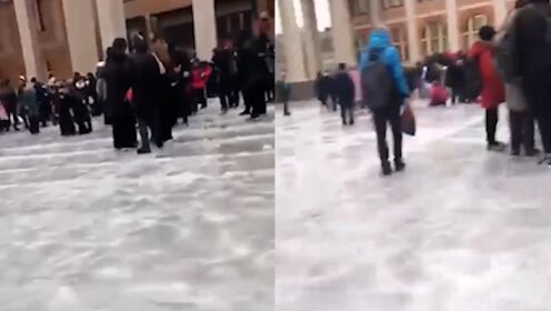 俄罗斯一座学校学生紧急疏散，却因地面结冰，被困在广场艰难行走