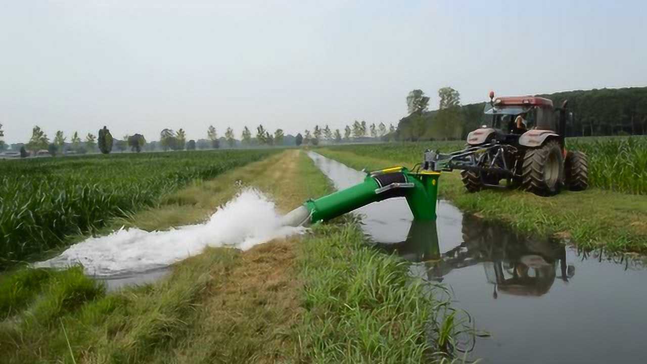 老外用拖拉机带动水泵抽水灌溉农田这抽水机有点牛