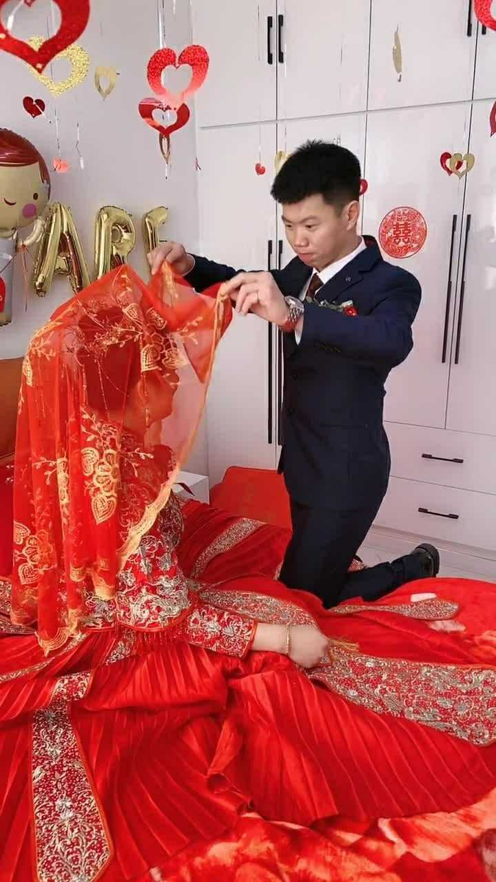 终于结婚了,新郎掀起新娘的红盖头,看起来很开心