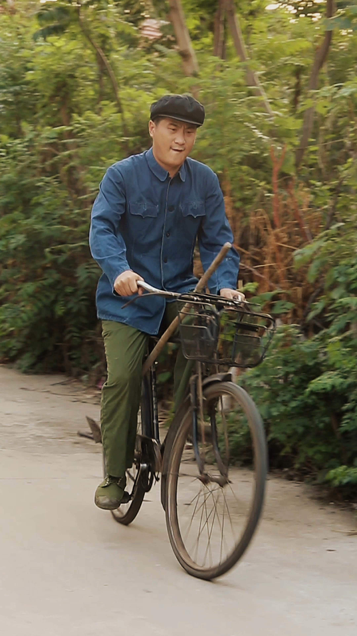 八十年代拿锄头下地干活,是这样子骑自行车的.你还记得吗?