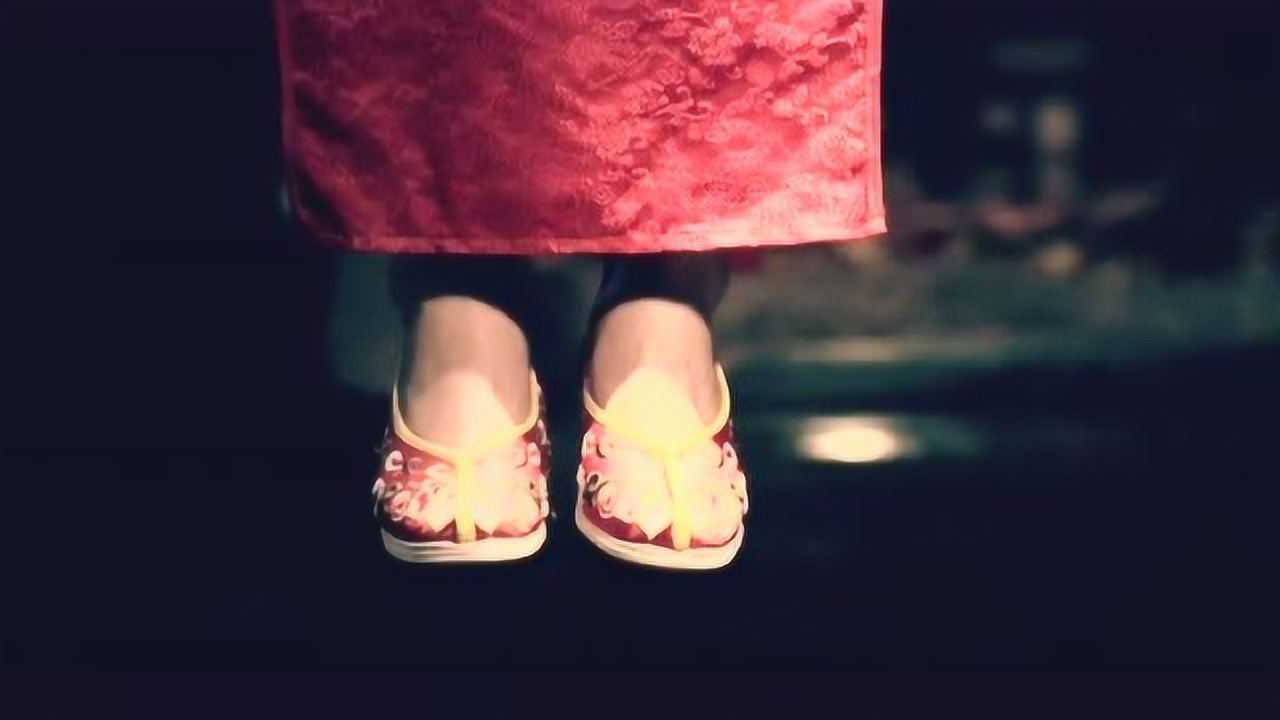 一个穿着红色旗袍的女人一边唱着戏曲一边上吊