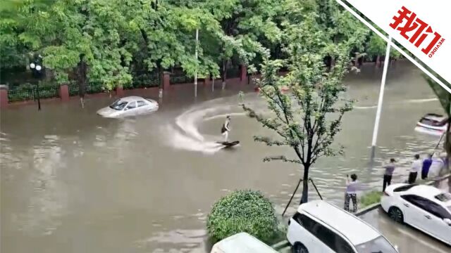 无锡暴雨一男子用动力冲浪板通过积水路段:为了上班打卡 顺便绕两圈