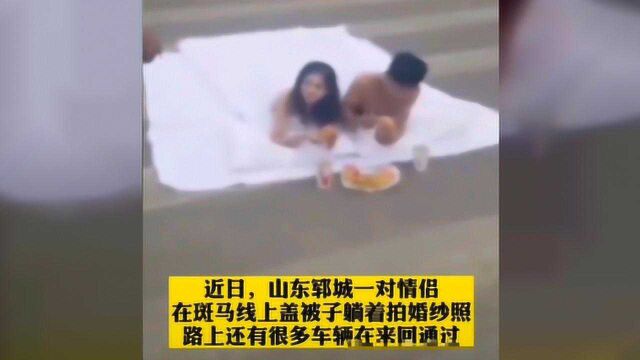 为拍个婚纱照也是拼了,一对男女马路上裹床单拍婚纱照