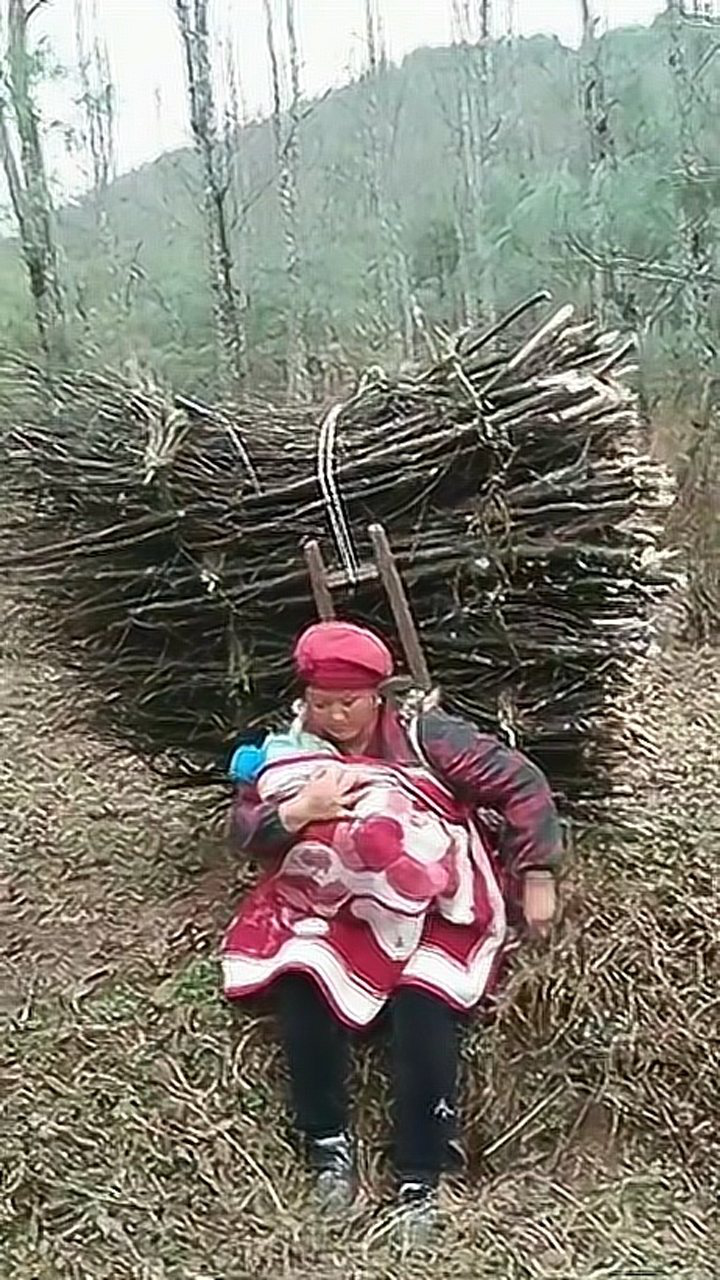 农村女汉子,背着柴和孩子