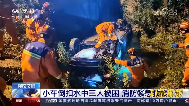 河南南阳一辆小轿车倒扣水中三人被困,消防展开紧急救援