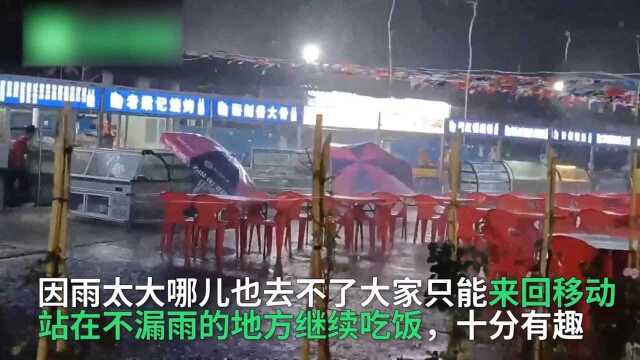 郑州暴雨,烧烤摊顶棚漏水似水帘洞,顾客来回移动吃饭