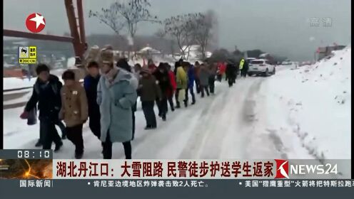 湖北丹江口：大雪阻路 民警徒步护送学生返家