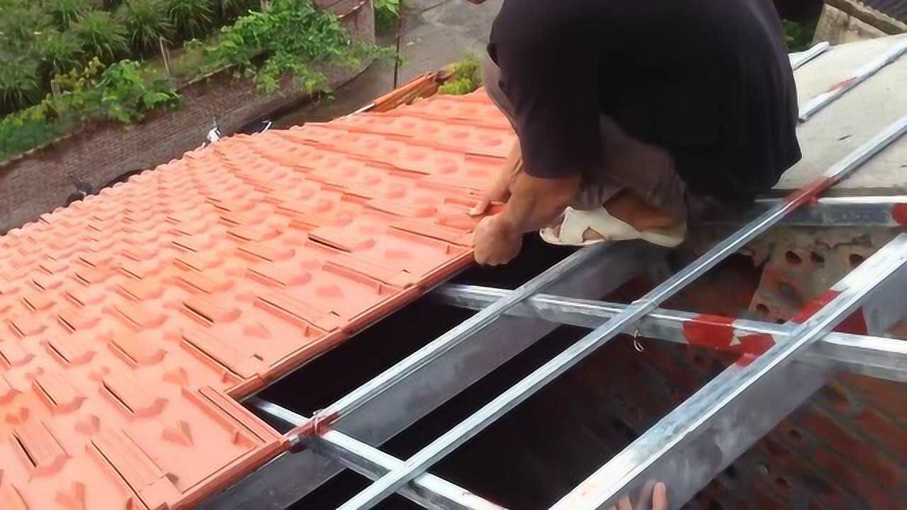 建筑师傅冒着雨在屋顶安装瓦片这样盖瓦不担心漏水吗