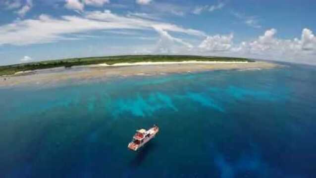 夏威夷的沙滩上,海浪不断地拍打着沙滩,天空湛蓝,风景极好