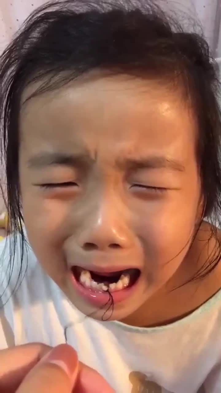 用绳子拔牙,小朋友害怕得快要露出来