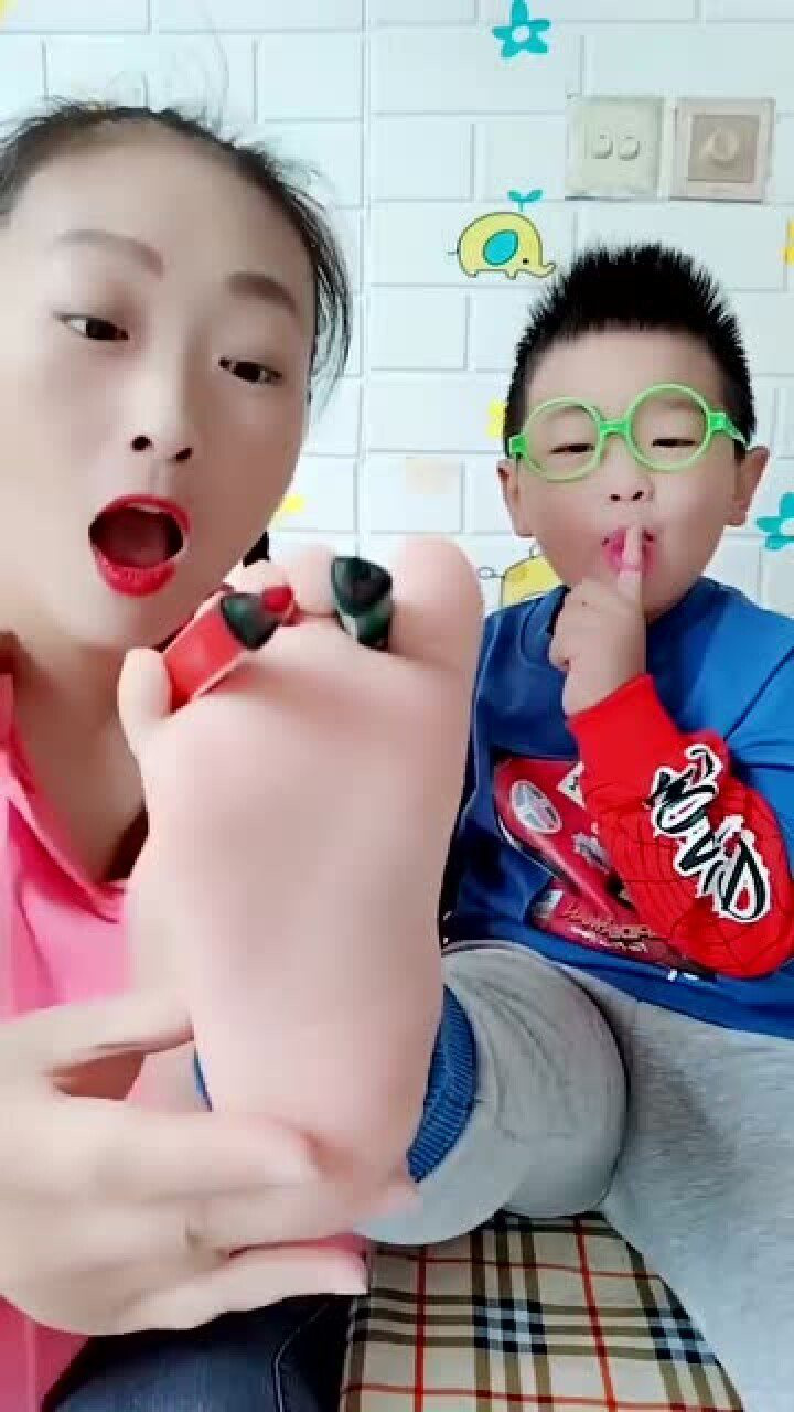 妈妈用彩笔在儿子的脚板上画画