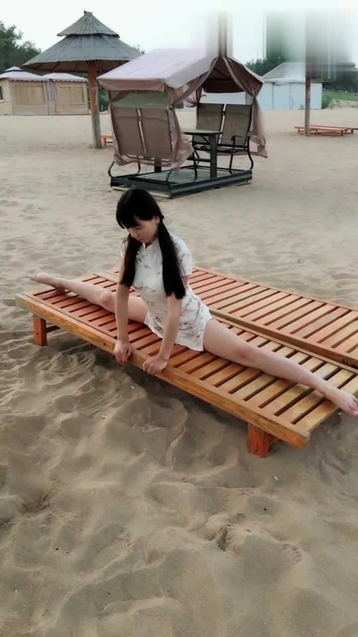 这位小姐姐火了穿着旗袍在沙滩劈一字马这大长腿没谁了