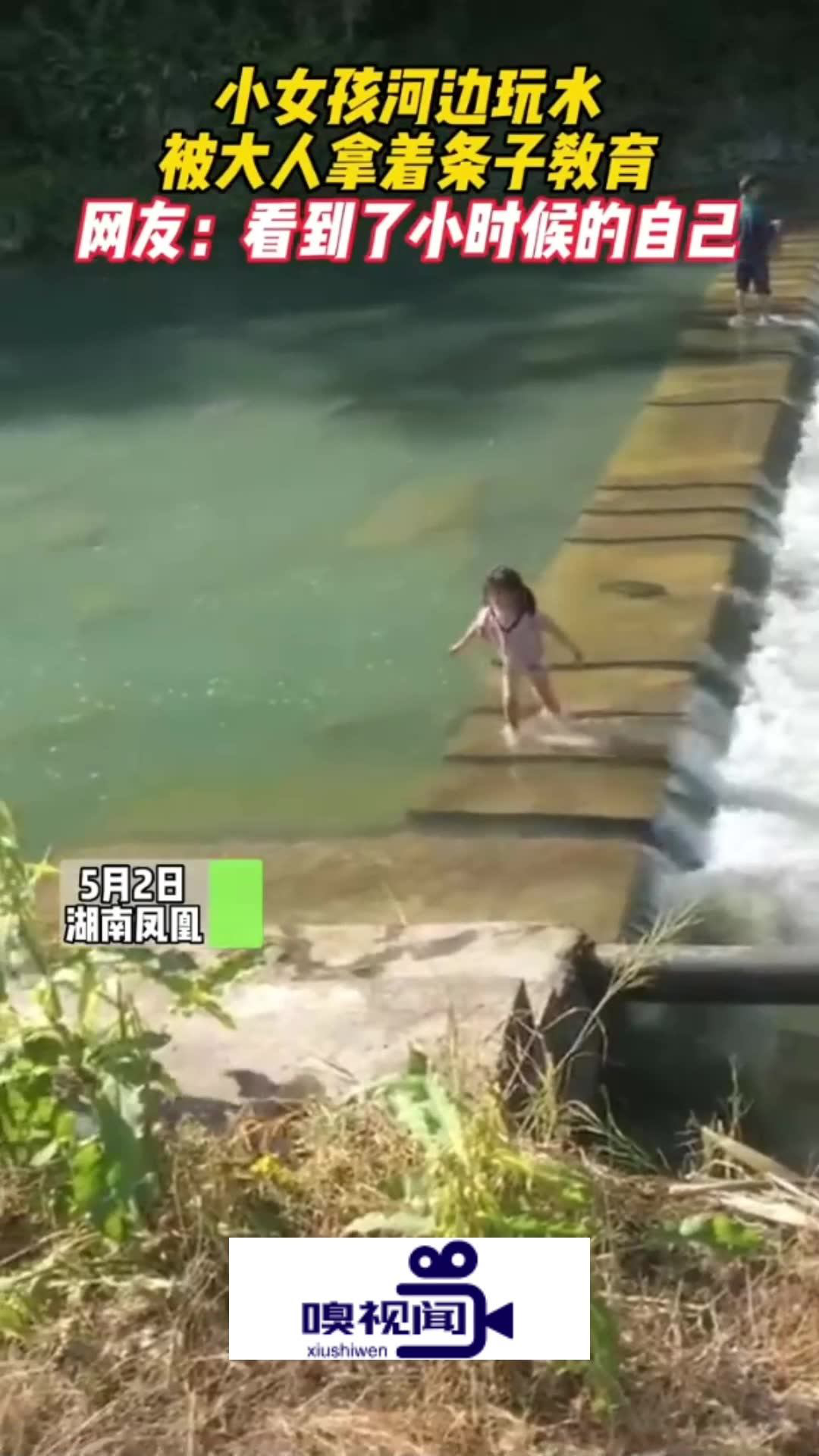 湖南鳳凰:小女孩河邊玩水,被大人拿著條子教育