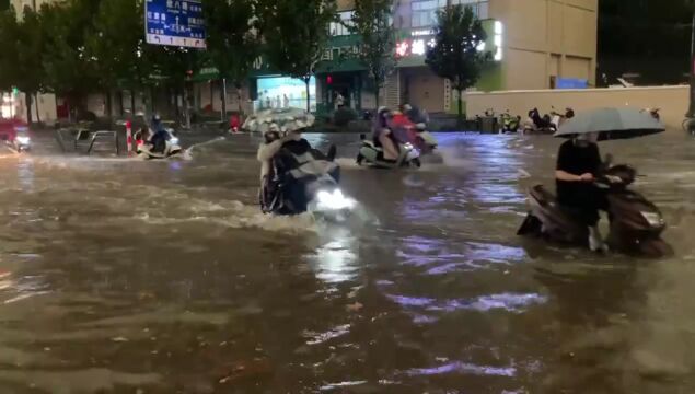 图集:下班时分郑州大雨如注 交警冒雨在路上指挥交通