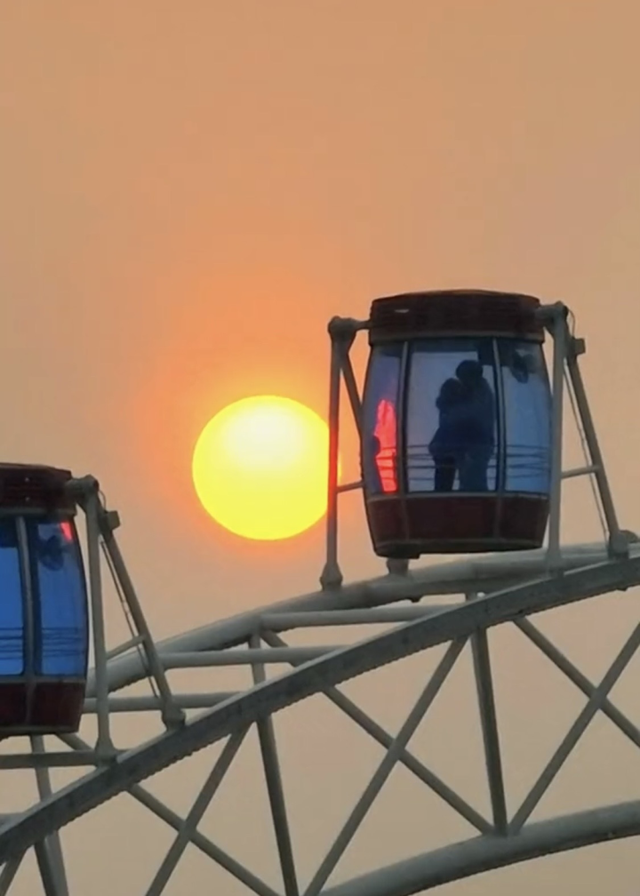 摄影师无意间见证的浪漫,夕阳下一对情侣在摩天轮里拥抱