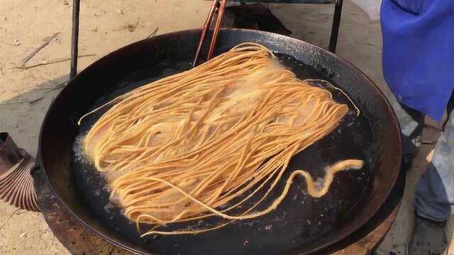 河南风味小吃炸馓子,口感酥脆特好吃,大伯一天能收入上千元