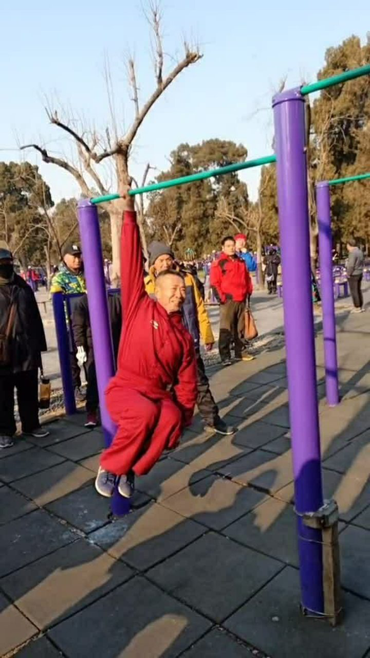 老大爷单手吊单杠已经坚持了十分钟还是这么稳重
