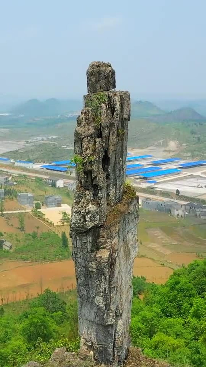 贵州大山一块薄薄的石头,上面还放着一块小石,像一个人一样屹立山顶